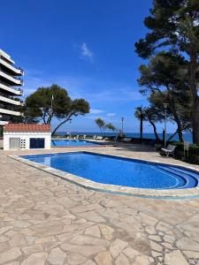 une piscine avec l'océan en arrière-plan dans l'établissement Passeig Maritim, à Miami Platja