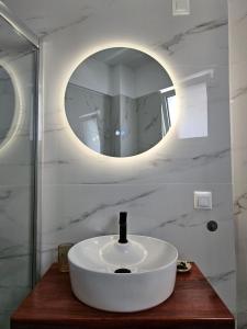 a bathroom with a white sink and a mirror at Chilies Rizes in Nafpaktos