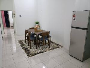 a kitchen with a table with chairs and a refrigerator at QM_Homestay Bagan Serai in Bagan Serai