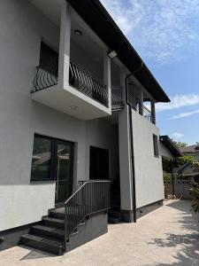 a white house with stairs and a balcony at Apartament Adela Giulia in Buzău