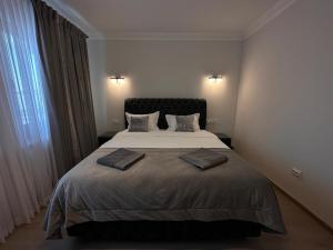 a bedroom with a large bed with two towels on it at Apartament Adela Giulia in Buzău