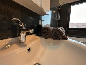 umywalkę z ręcznikiem i kranem w łazience w obiekcie Apartament Adela Giulia w mieście Buzău