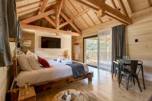 Cette chambre en bois comprend un grand lit. dans l'établissement Les Cabanes Suspendues, à Satillieu