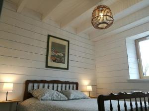 1 dormitorio con cama y lámpara de araña en Gîte atypique classé 2* 8 personnes Côtes-d'Armor, 