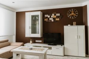 Apartman Stil في بوغوينو: غرفة معيشة مع تلفزيون وخزانة بيضاء