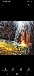 a painting of a man in a kayak in front of a waterfall at Pousada Familiar Encanto da Chapada in Carolina