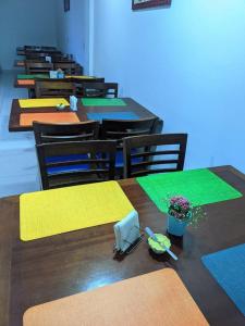 a classroom with tables and chairs with yellow and green mats at Pousada Monsenhor in Cachoeira Paulista