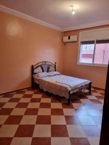 a bedroom with a bed and a checkered floor at Apartment in home tafraoute with terrace in Tafraout