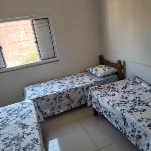 a room with two beds and a window at Hostel da Spipe in Campo Grande