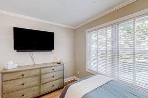 a bedroom with a dresser and a flat screen tv at Jump Off Rock Retreat in Hendersonville