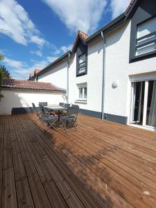 a patio with a table and chairs on a wooden deck at Maison de ville avec terrasse in Épinal