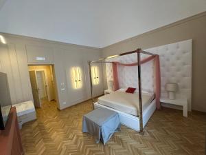 a bedroom with a four poster bed and a television at Palazzo Bonomi in Bisceglie