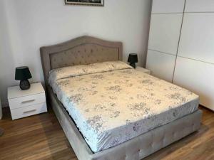 a bedroom with a bed and two night stands with lamps at New apartment close to the city center! in Milan