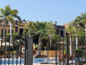 un complejo con piscina y palmeras en Vacation home La Duquesa, en Adeje