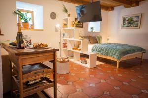 - une chambre avec un lit et une table avec une bouteille de vin dans l'établissement Studio Apartment Pr' Mirotu, à Osilnica