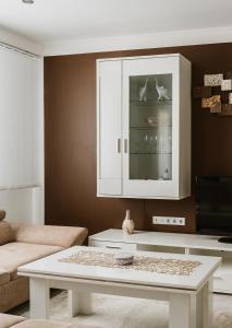 Apartman Stil في بوغوينو: غرفة معيشة مع طاولة قهوة وخزانة