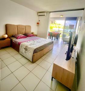 ein Schlafzimmer mit einem Bett und einem Flachbildfernseher in der Unterkunft STUDIO VUE MER VILLAGE VIVA BAS DU FORT, Gosier in Le Gosier