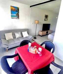 - un salon avec une table et des chaises rouges dans l'établissement STUDIO VUE MER VILLAGE VIVA BAS DU FORT, Gosier, au Gosier