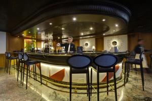 a man standing at a bar in a restaurant at Grupotel Parc Natural & Spa in Playa de Muro