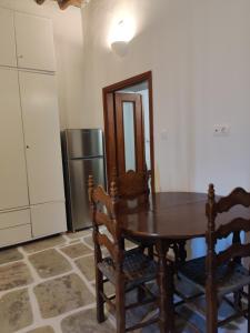 a kitchen with a wooden table and a refrigerator at Neo-Traditional Sunrise Apartment in Ios Chora