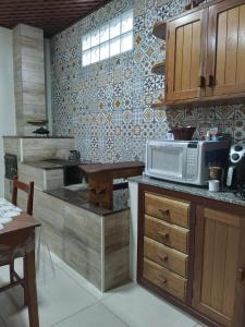 a kitchen with a microwave and a table in it at Sítio Olho de Boneca in Itamonte