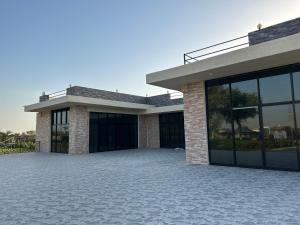 a house with a large patio in front of it at The Mountain Farm in Ras al Khaimah
