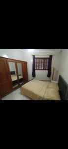 um quarto com uma cama e uma janela em Appartement meublé em Meknès