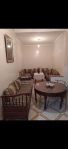 ein Wohnzimmer mit einem Sofa und einem Tisch in der Unterkunft Appartement meublé in Meknès