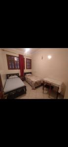 ein Schlafzimmer mit 2 Betten und einem Tisch darin in der Unterkunft Appartement meublé in Meknès