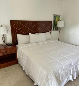 a bedroom with a large white bed with two lamps at Sun Fun Hotel in Nassau