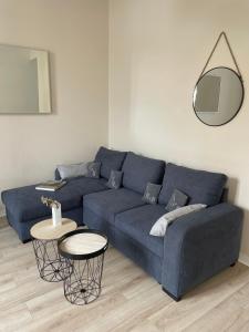 ein Wohnzimmer mit einem blauen Sofa und einem Tisch in der Unterkunft L échappée Belle in Rochefort