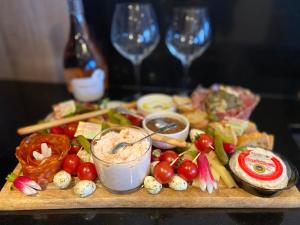 a cutting board with vegetables and dip and two wine glasses at LA PERLE BLEUE, Centre ville Valence,Proche gare in Valence +1 photo