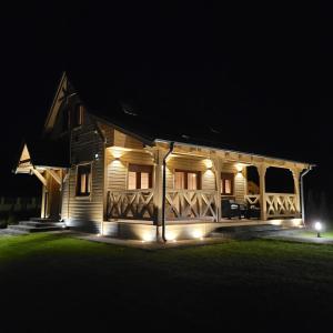 uma casa de madeira iluminada à noite com luzes em Sękowy Domek em Świeradów-Zdrój
