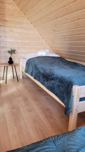 um quarto com uma cama num quarto de madeira em Sękowy Domek em Świeradów-Zdrój