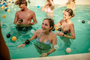 a group of people playing with balls in a swimming pool at Che Puerto Escondido Hostel & Bar Adults Only in Puerto Escondido