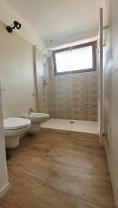 ein Bad mit einem Waschbecken, einem WC und einem Fenster in der Unterkunft Maison AnnaBelle in Ceniga