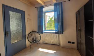 Zimmer mit blauer Tür, Ventilator und Fenster in der Unterkunft Maison AnnaBelle in Ceniga