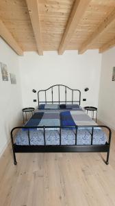 ein großes Bett in einem Zimmer mit Holzdecke in der Unterkunft Maison AnnaBelle in Ceniga