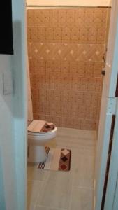 a small bathroom with a toilet and a shower at Hostal María Fernanda in Santo Domingo