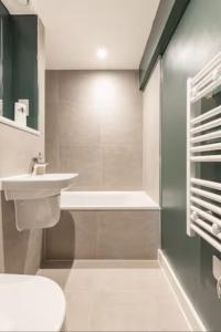 ein Badezimmer mit einem Waschbecken, einem WC und einer Badewanne in der Unterkunft Two Bedrooms Exquisite En-Suite Apartment Deansgate in Manchester