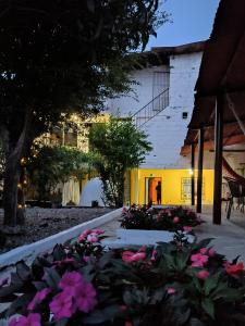 un jardín con flores rosas frente a un edificio en Magic Jardín Hostel, en Jardín