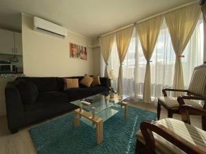 uma sala de estar com um sofá preto e uma mesa em Hermoso Departamento aire acondicionado, Internet em Talca