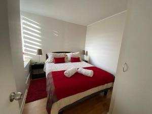 a bedroom with a bed with two towels on it at Hermoso Departamento aire acondicionado, Internet in Talca