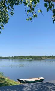 a boat sitting on the shore of a lake at Glempings Velo Latgale in Izvalta