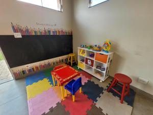 a classroom with a chalkboard and a table and stool at Hotel Pousada Parque das Águas in Olímpia