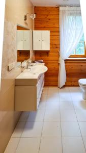 a bathroom with two sinks and a toilet at Jaunakmeņi in Priežmale