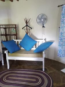 a white bench with blue pillows in a room at Alooma Studio homes in Galu