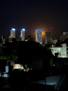 a city skyline at night with blue lights at Departamento moderno en Rosario calidad & ubicación in Rosario