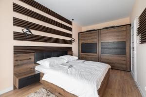 a bedroom with a large bed and a wooden wall at City View Tower in Poznań