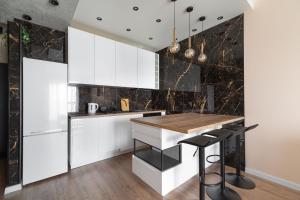 a kitchen with white cabinets and black countertops at City View Tower in Poznań